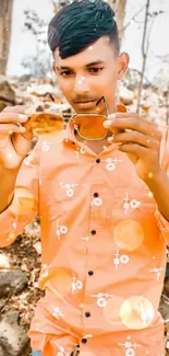 Stylish person in vibrant orange shirt holding sunglasses outdoors.