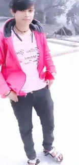 Person in a bright pink jacket standing outdoors.