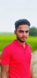 Vibrant portrait of a man in a red shirt standing in a lush green field.