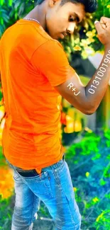 Outdoor young man in orange shirt and jeans.