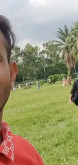 Young person smiling in a lush green park setting.