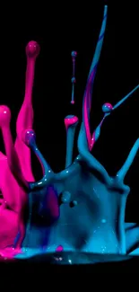 Vibrant pink and blue paint splash on black background.