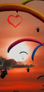 Colorful paragliders soaring across a stunning orange sunset sky.