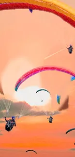 Paragliders soaring during vibrant sunset.