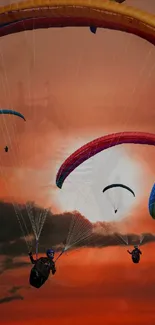 Paragliders soaring against a vibrant sunset sky.