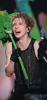 Performer with vibrant green prop and joyful expression on stage.