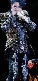 Performer in striking metallic armor on stage with dynamic lighting.