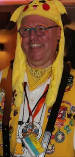 Person in a Pikachu costume with badges, smiling.