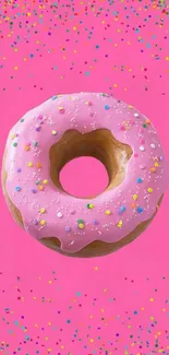 Pink donut with vivid sprinkles on a striking pink background.