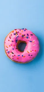 Pink donut with sprinkles on a blue background.