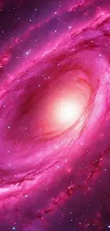 Vibrant pink galaxy with bright core in space.