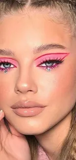 Vibrant pink makeup art on a model's face, showcasing bold beauty style.