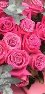 Close-up of a vibrant pink rose bouquet with lush greenery.