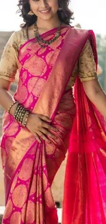 Elegant woman in vibrant pink sari surrounded by historic stone architecture.