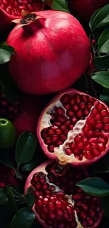 Vibrant close-up of pomegranates with green leaves as wallpaper background.
