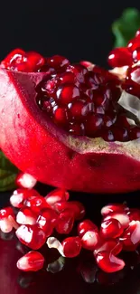 Vibrant red pomegranate with juicy seeds against a dark background.