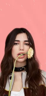 Woman with daisy on pastel pink background.