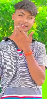 Fashionable young man in striped shirt with vibrant green background.