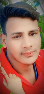 Portrait of a young man in a red shirt outdoors.