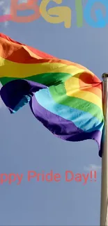 Vibrant rainbow Pride flag waving against a clear sky.