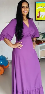 Woman in a vibrant purple dress in a modern living room setting.