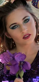 Woman in purple dress holding a purple flower.