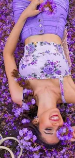 Woman in purple floral outfit lying on purple flowers.