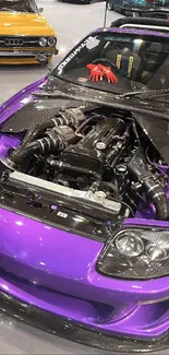 Vibrant purple sports car with open hood displaying engine.