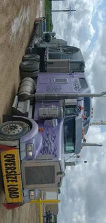 Purple truck with flame decals under a cloudy sky