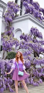 Woman in purple outfit with lush purple flowers in urban setting.