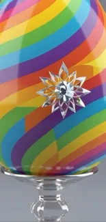 Rainbow-striped egg with decorative floral accent on a grey background.