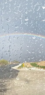 Beautiful rainbow arching over a quiet rural road under a cloudy sky.