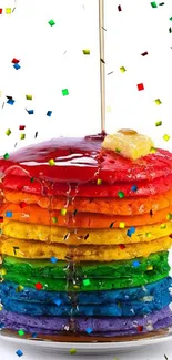 Colorful stack of rainbow pancakes with syrup.