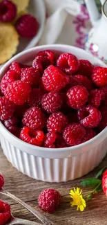 Bowl of fresh raspberries on a wooden table with natural decor.