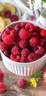 Fresh raspberries in a white bowl on a rustic wooden table.