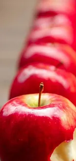 Vibrant red apples lined up as mobile wallpaper background.