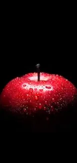 Vibrant red apple with droplets on black background.