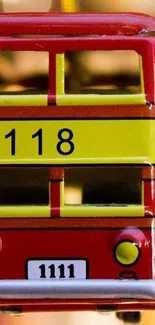 Front view of a red toy bus with yellow stripes and the number 118.