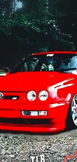 Vibrant red car against a lush forest backdrop.