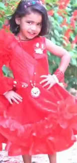 Young girl in a vibrant red dress with a garden background.