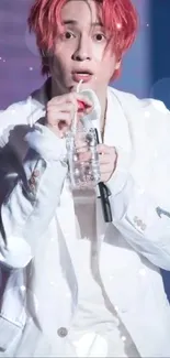 Energetic performer in a white outfit with striking red hair on stage.