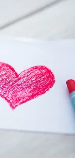 Red crayon heart drawn on white paper background.