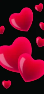 Glossy red hearts on black background mobile wallpaper.