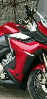 Red motorcycle with sleek design on pavement background.