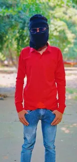 Man in red shirt standing outside with lush green background.