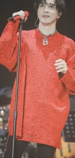 Performer in vibrant red outfit on stage.