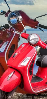 Red retro scooters parked by the sea.