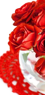 Vibrant bouquet of red roses in a glass vase on a white background.