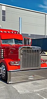 Vibrantly painted red semi truck parked outside an industrial building.