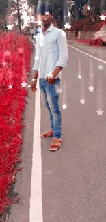 Person standing on road with vibrant red foliage.